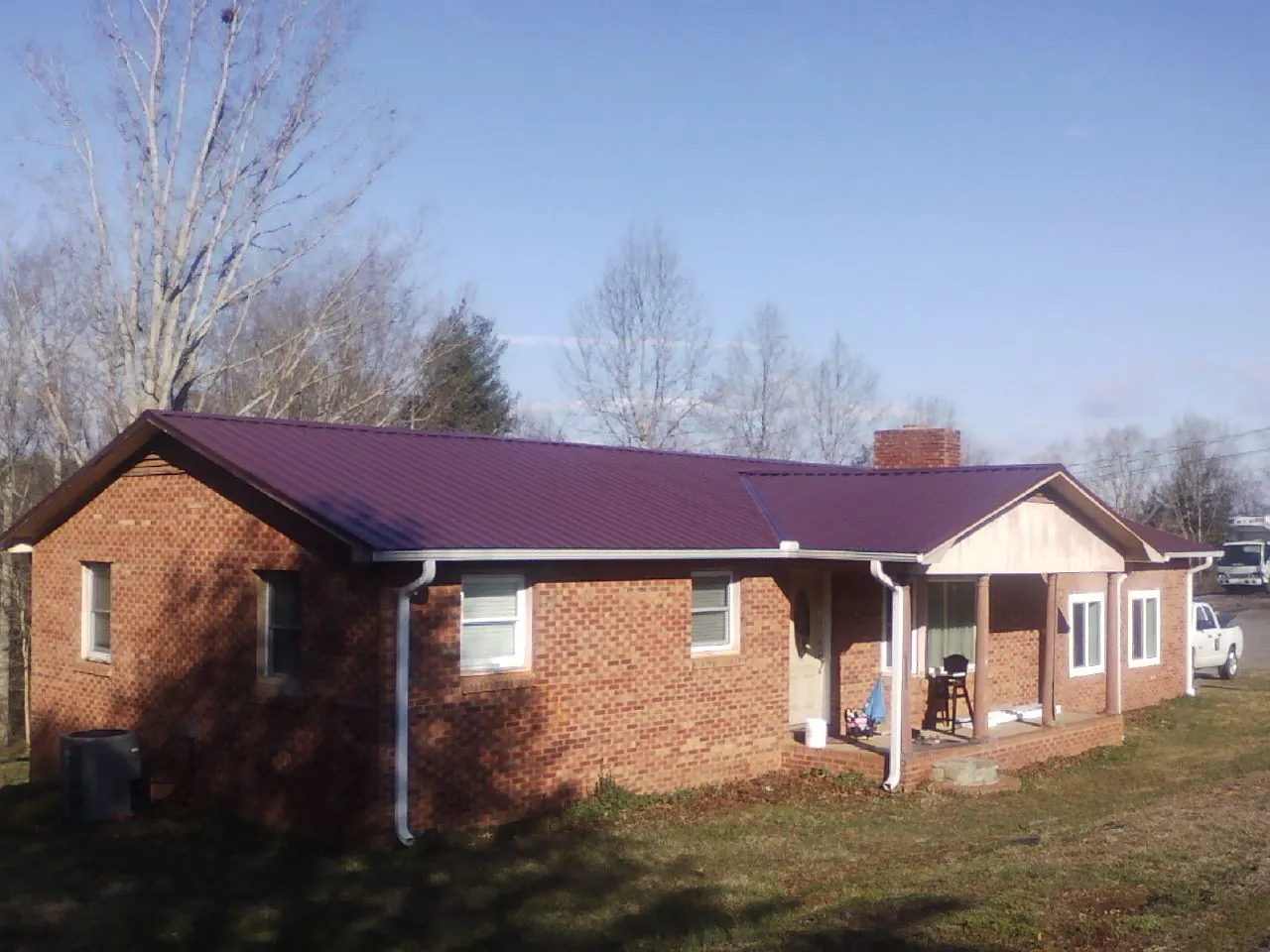 Burgundy metal roof on a brick ranch home with a new addition in Dumont