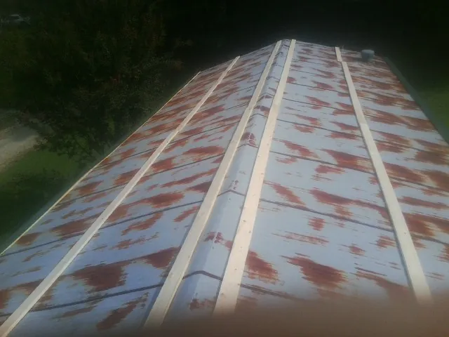 Rusted metal roof panels with new wood purlins before replacement — Storm Damage Roof Repair in Dumont by Roofing Brothers